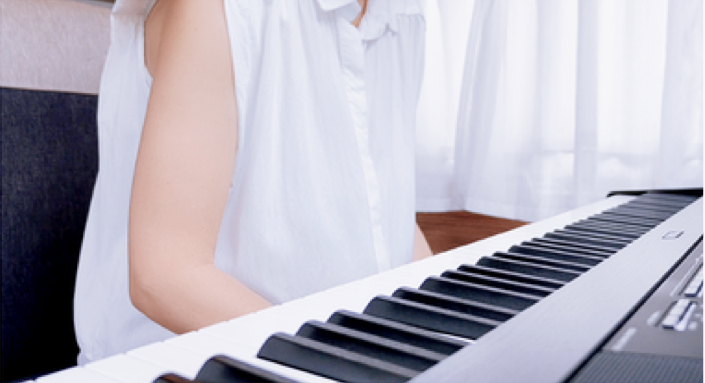 A pianist leaning the torso slightly forward at the keyboard, arms hanging down and hands not yet on the keys.