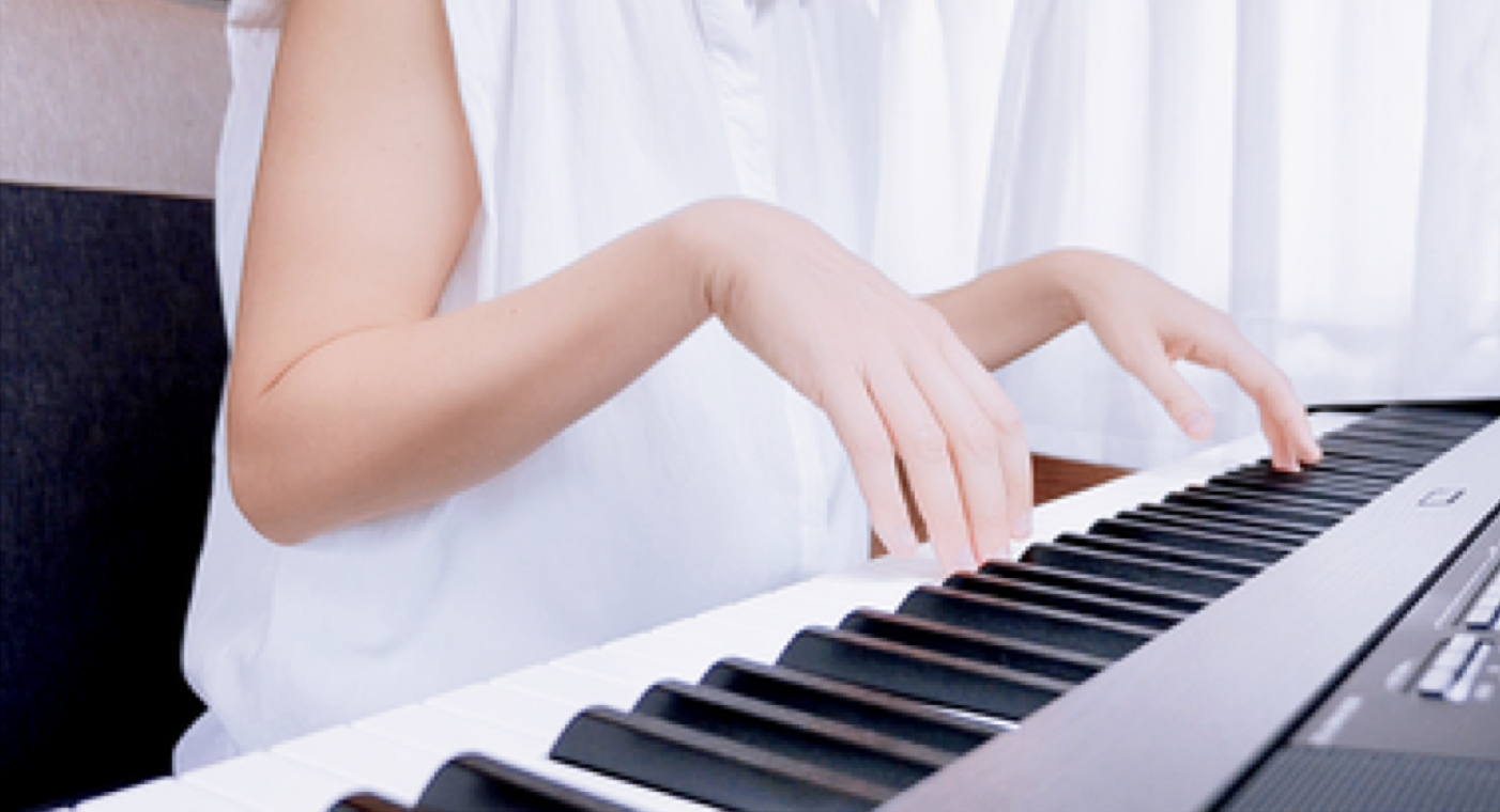 A pianist bringing both hands close over the keys, fingertips nearly brushing the surface.