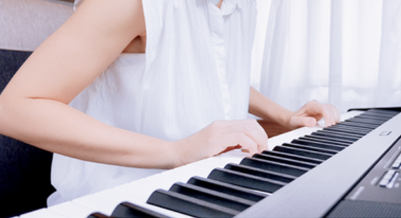A pianist with hands landed on the keys, fingertips resting on the keyboard and playing.