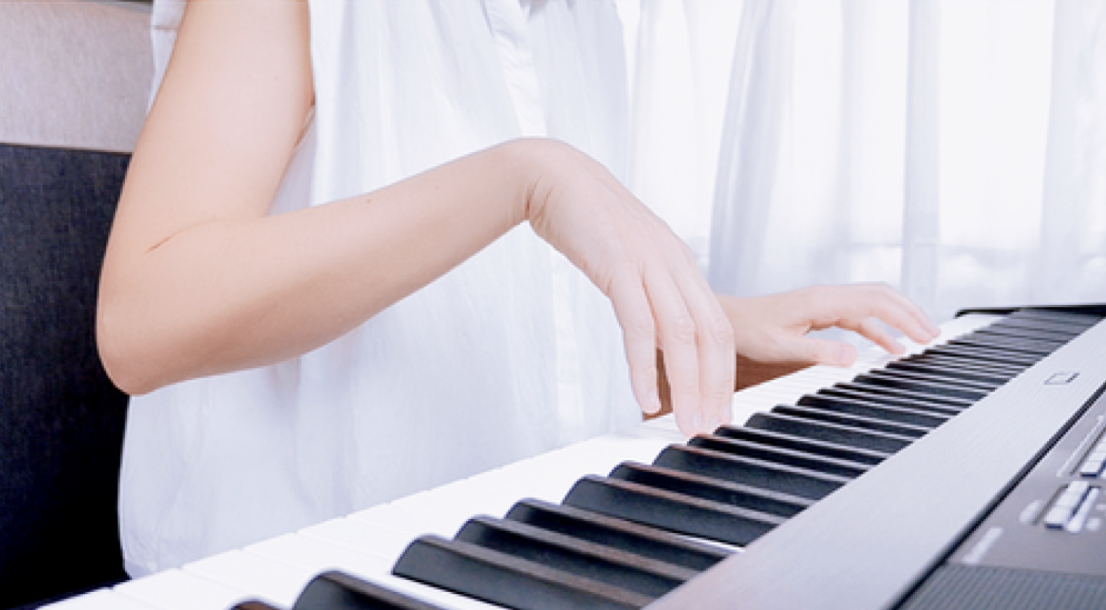 A pianist with both hands over the keyboard and both arms engaged, one elbow landing before the other.