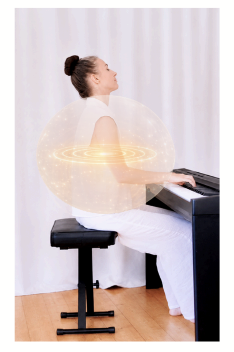 A pianist seated at the piano with a warm, glowing energy field pictured beneath the upper arms.